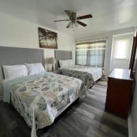 A hotel room with two beds and a ceiling fan.