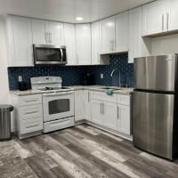 A kitchen with white cabinets , stainless steel appliances , a stove , refrigerator , microwave and sink.