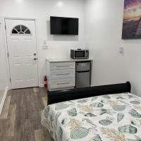 A bedroom with a bed , dresser , microwave and television.