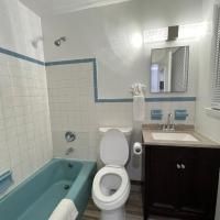 A bathroom with a toilet , sink , bathtub and shower.