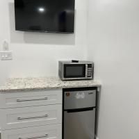 A kitchen with a microwave , dishwasher , refrigerator and television.