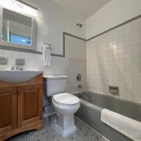 A bathroom with a toilet , sink , bathtub and mirror.