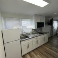 A kitchen with a refrigerator , sink , microwave and television.