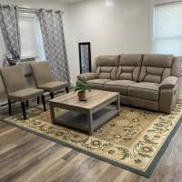 A living room with a couch , chairs , coffee table and rug.