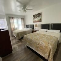 A hotel room with two beds and a ceiling fan.