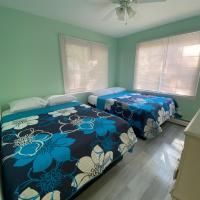 A bedroom with two beds and a ceiling fan.