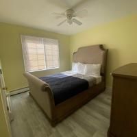 A bedroom with a bed , dresser , and ceiling fan.