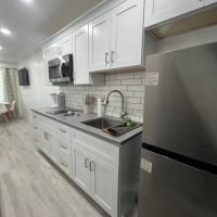 A kitchen with white cabinets , stainless steel appliances , a sink , and a refrigerator.