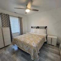 A bedroom with a bed , nightstand , ceiling fan and window.