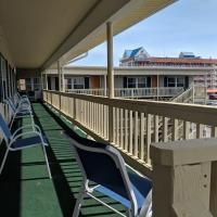 There are many chairs on the balcony of a hotel.