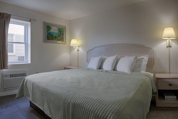 A hotel room with a king size bed and a window