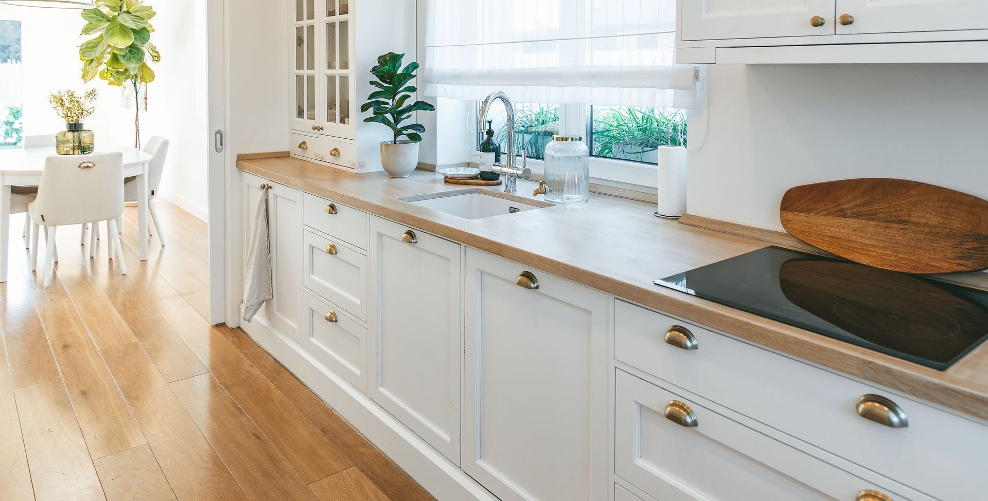 a kitchen with white cabinets and wooden counter tops and a stove top oven .