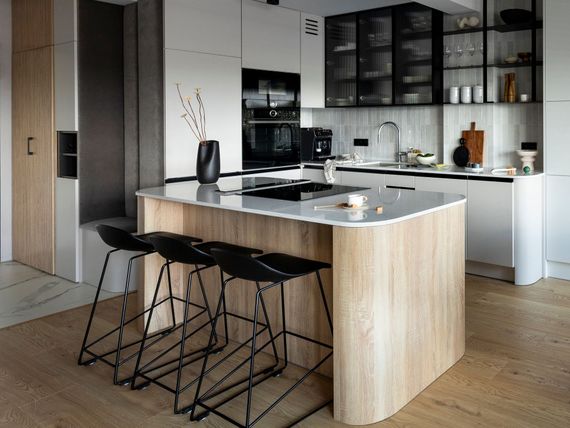 a kitchen with a wooden island and black stools
