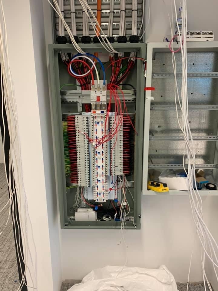 Electrical Panel With Rows of Breakers and Bundled Wires Inside a Wall Cabinet — Quik Fire Electrical in Kelmscott, WA