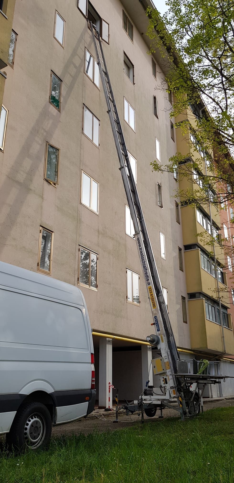 Per spostare oggetti da un furgone a una finestra di un condominio a più piani viene utilizzato un elevatore verticale.