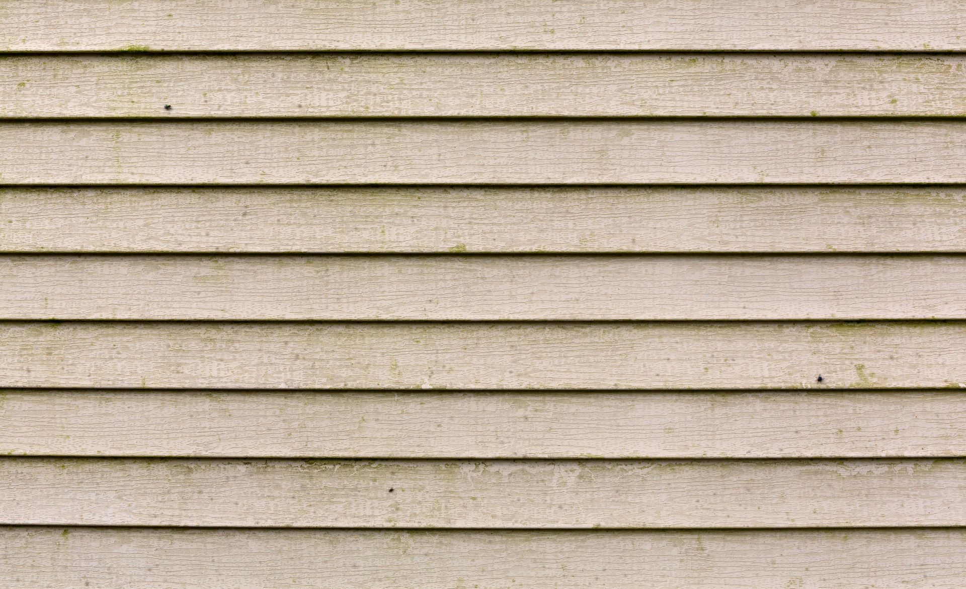 Horizontal, light-colored siding with horizontal grooves, possibly weathered or dirty.