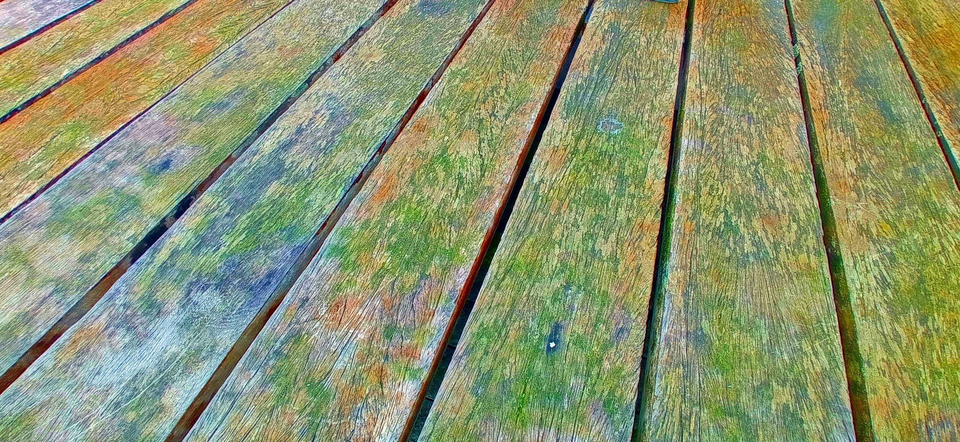 Close-up of weathered, colorful wooden planks, arranged diagonally.