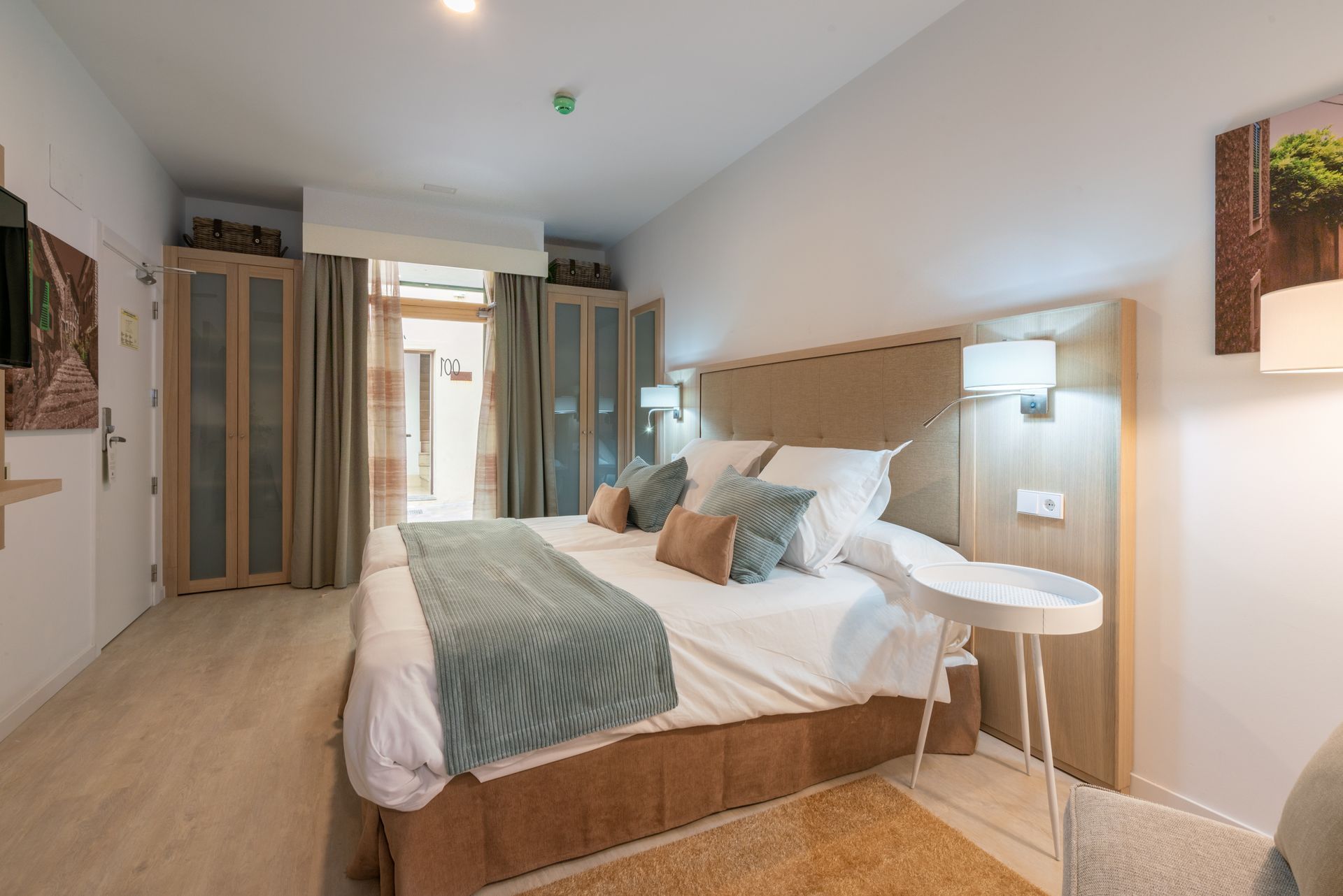 Chambre avec un lit king-size, une table de chevet et une porte ouverte sur une autre pièce. Murs et literie.