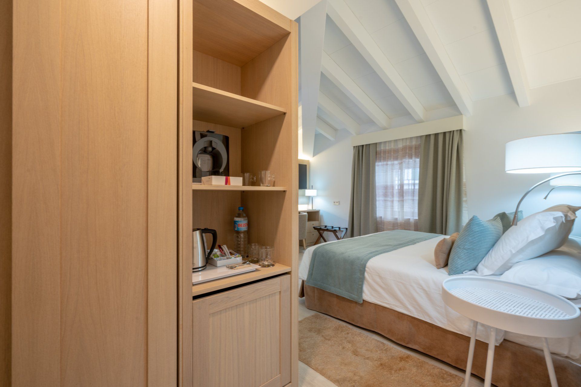Chambre avec placard en bois clair, étagères avec objets et un lit aux accents bleus.