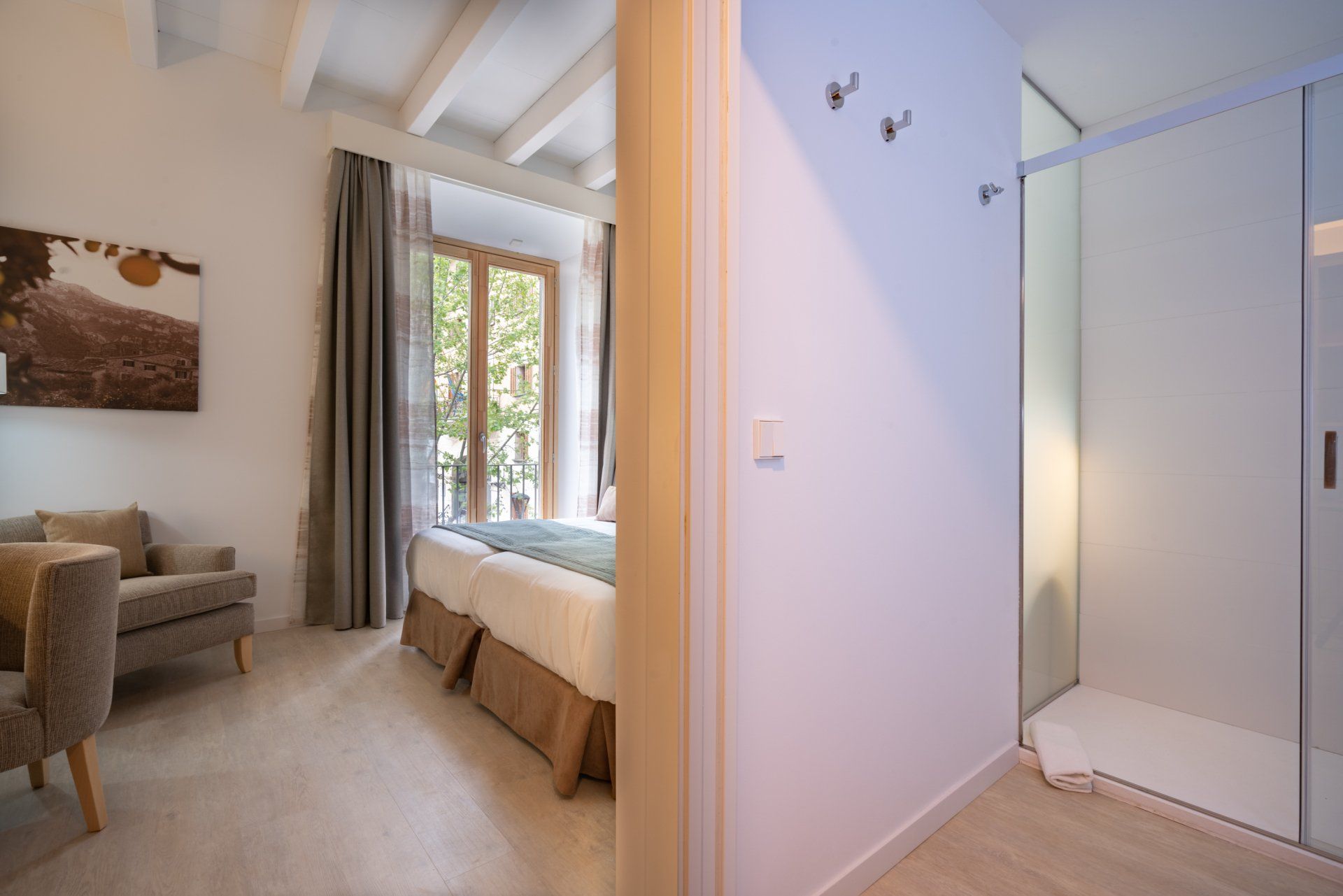 Bedroom interior with doorway to bed, shower, and a seating area with a couch.
