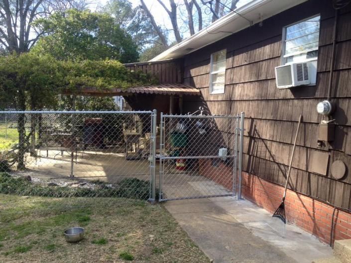chain link fence on side of brown house