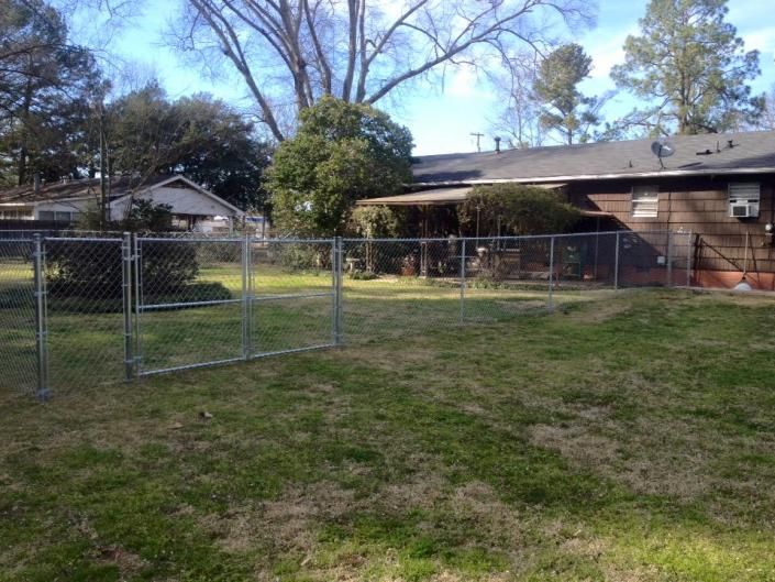 chain link fence on side of brown house