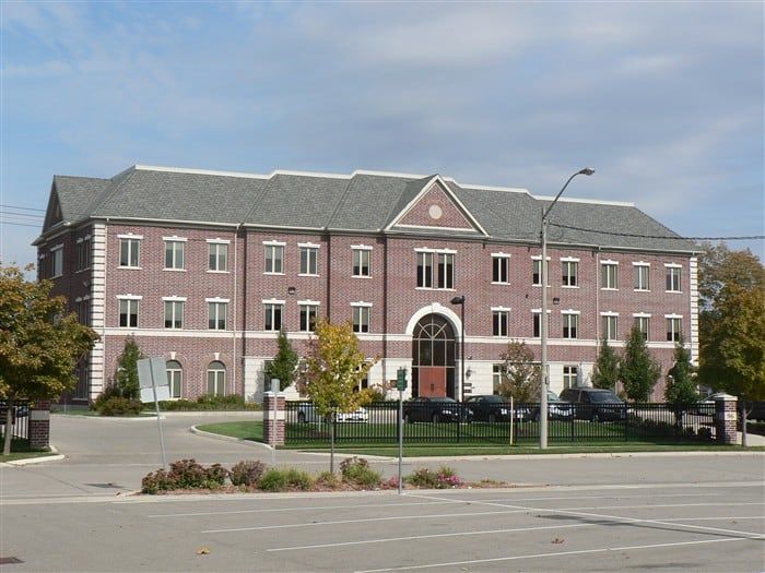 A large brick building with a parking lot in front of it
