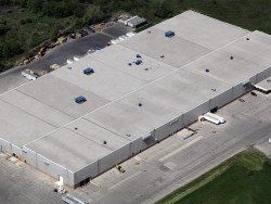 An aerial view of a large warehouse with trucks parked in front of it.