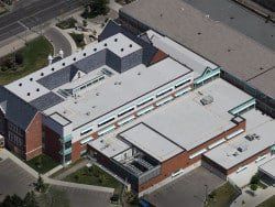An aerial view of a large building with a white roof.