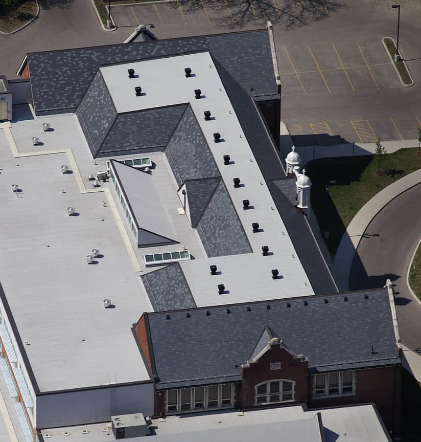 An aerial view of a large building with a white roof