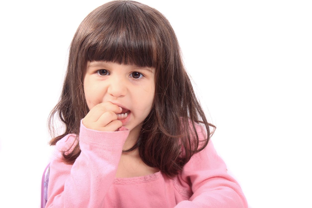 four year old girl touching loose tooth