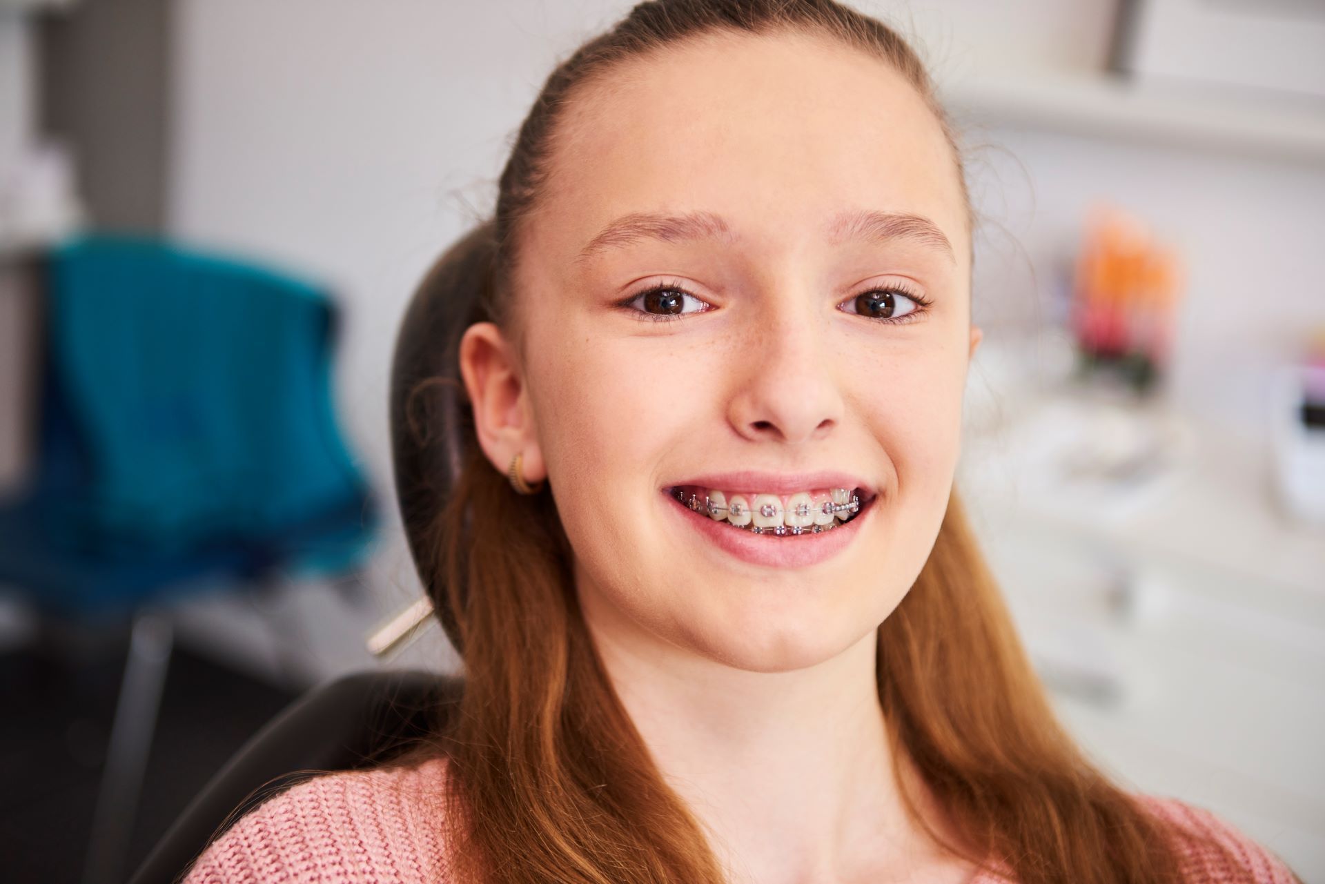 girl with braces smiling at dentist