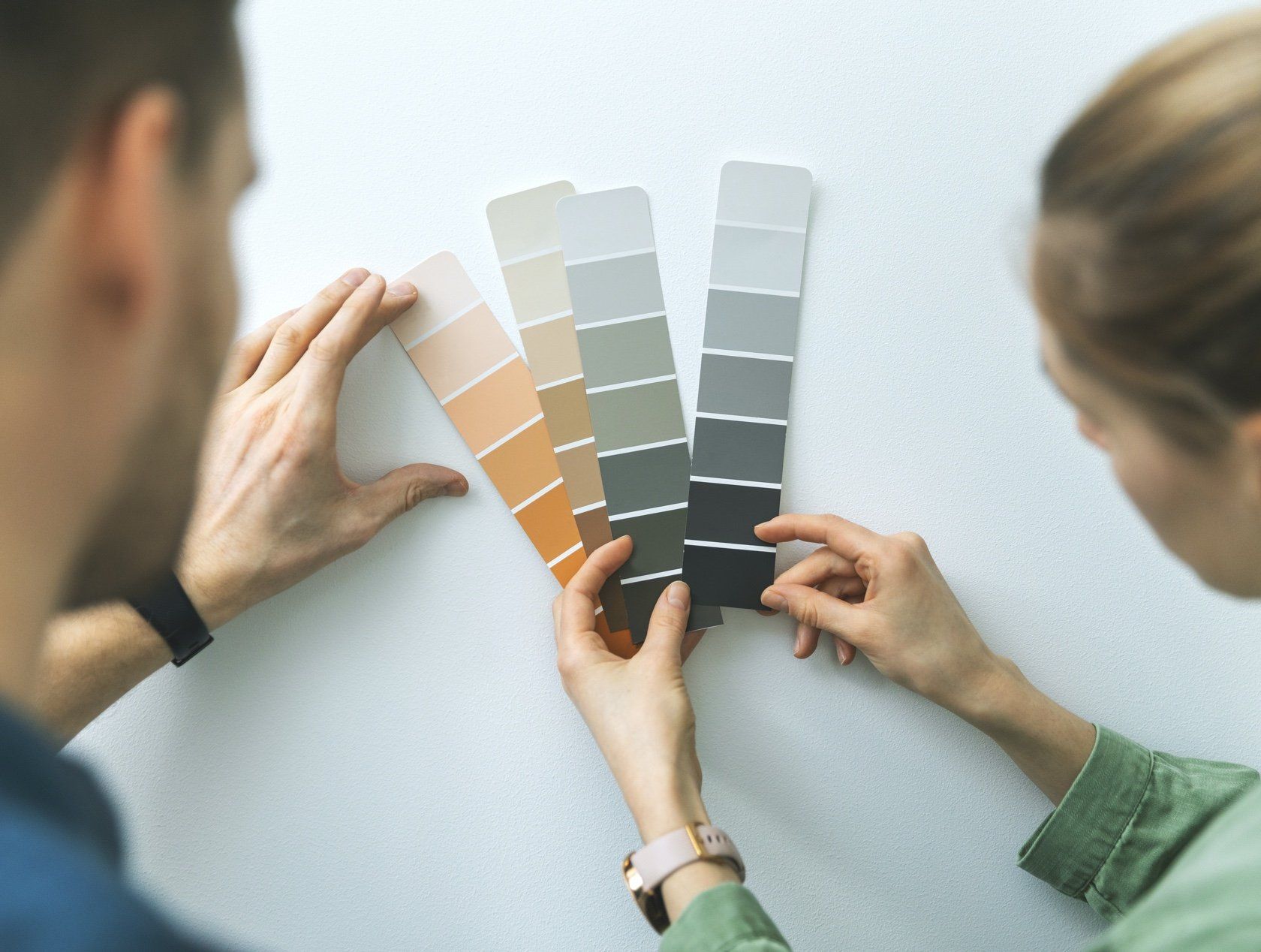 This is a photo of a couple looking at paint shade options.