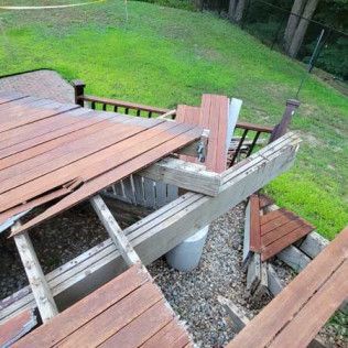 A wooden deck with a lot of pieces of wood laying on the ground.