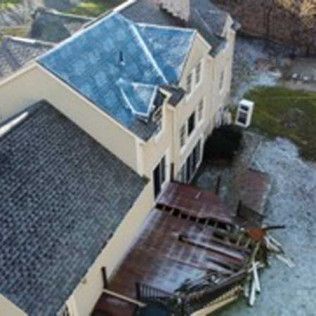 An aerial view of a house with a blue roof.