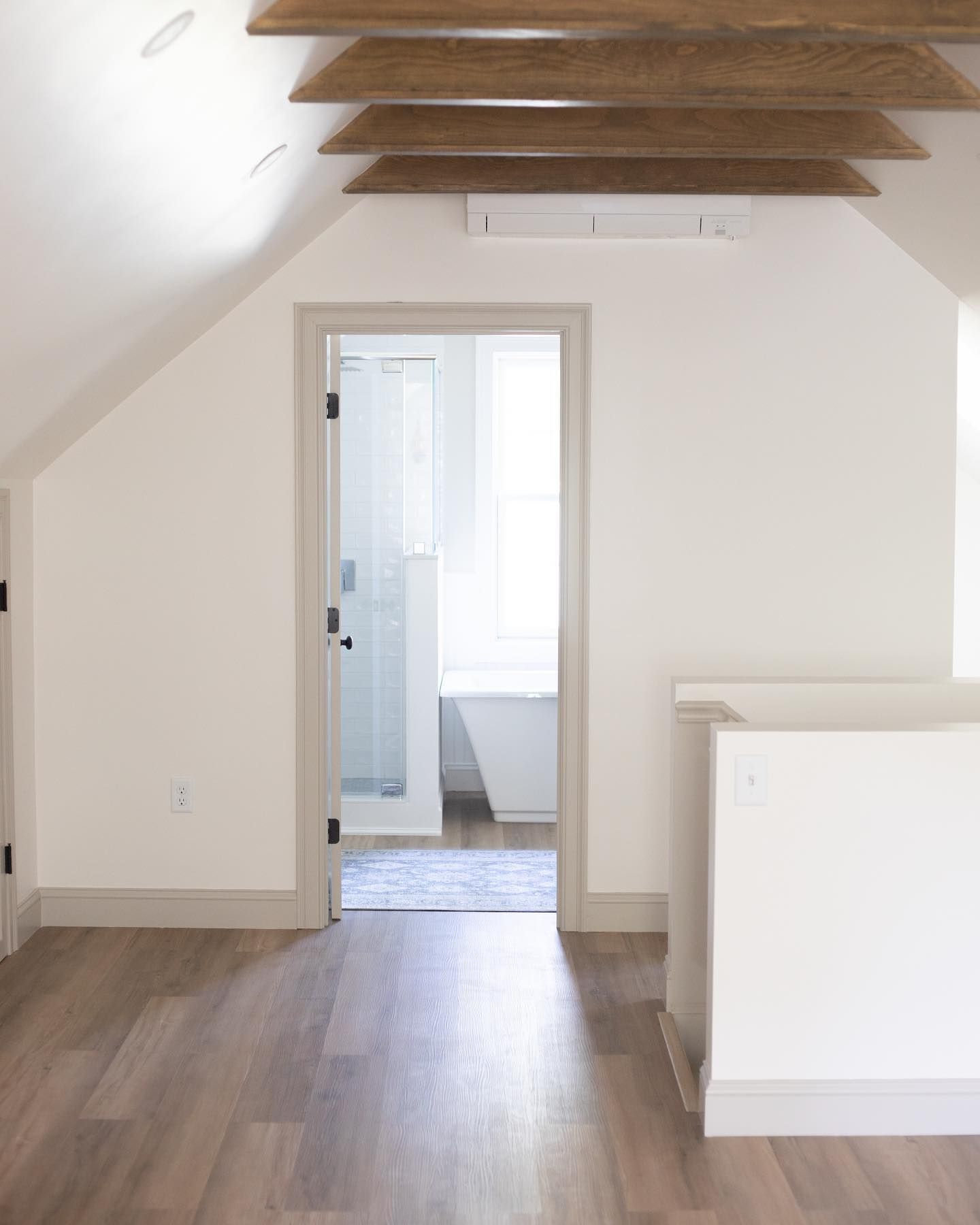 An empty room with a door that leads to a bathroom.