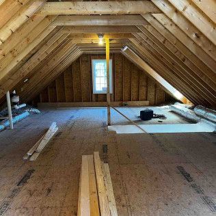 An attic with wooden beams and a window.