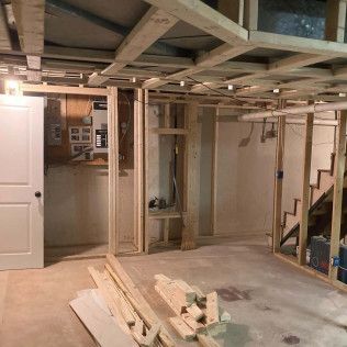A basement under construction with wooden beams and stairs.