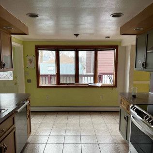 There is a large window in the middle of the kitchen.