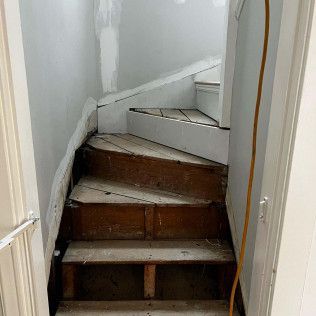 A set of wooden stairs leading up to a bathroom in a house.