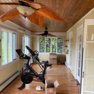 A room with a ceiling fan and a bicycle in it.