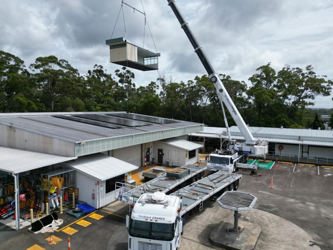 A Crane Is Lifting A Container Into A Building — ProCert Cranes In Coolum Beach, QLD