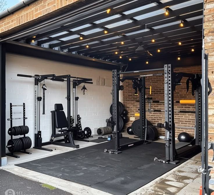A garage filled with lots of gym equipment and a brick wall.