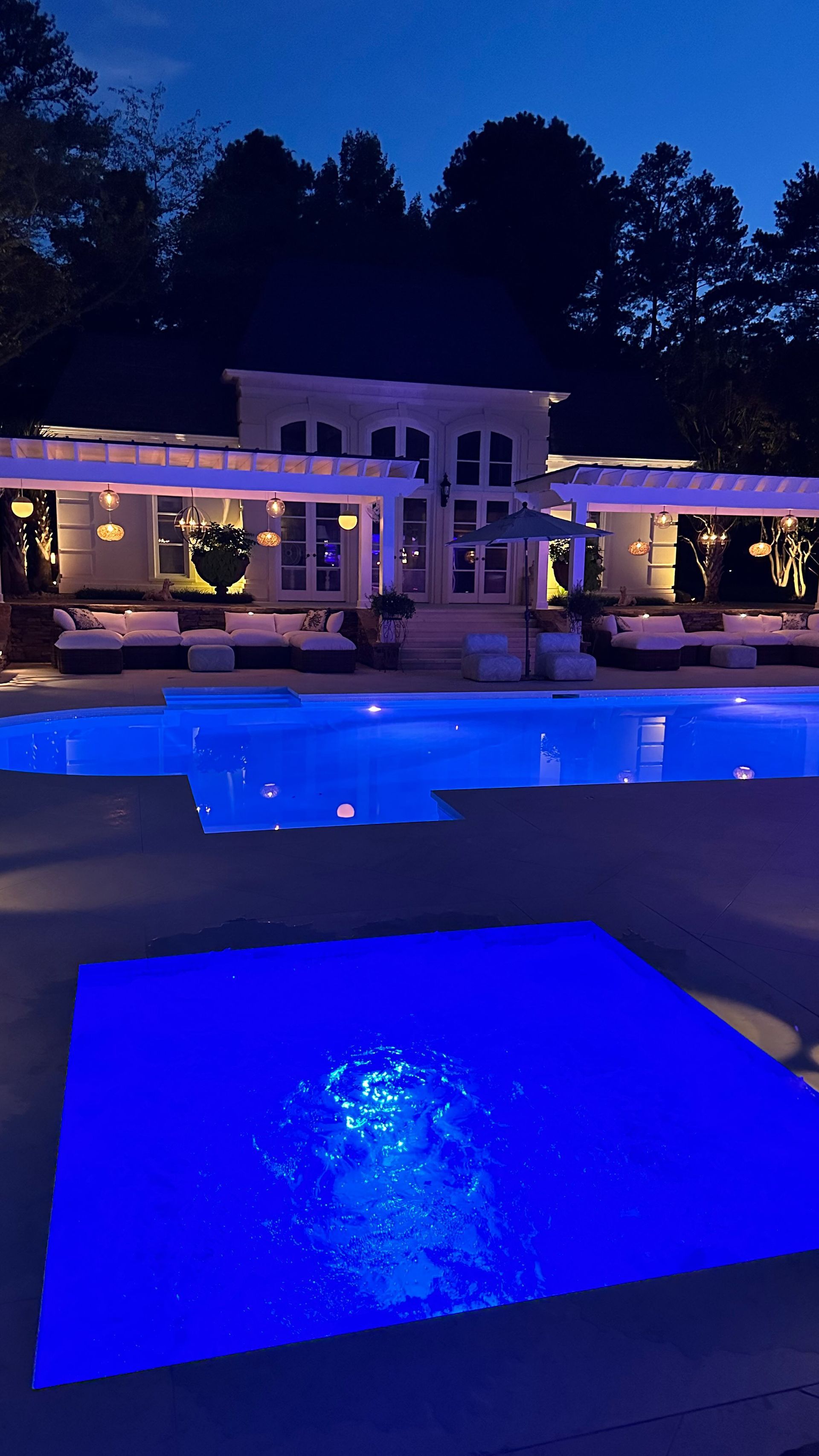 A large swimming pool is lit up at night