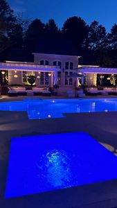 A large swimming pool is lit up at night