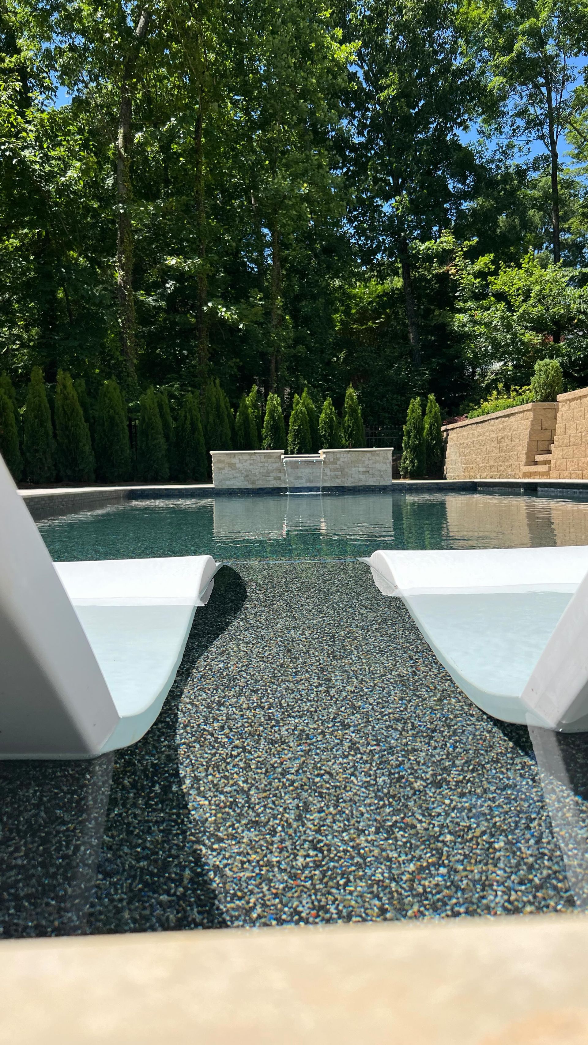 A couple of chairs sitting next to a swimming pool.