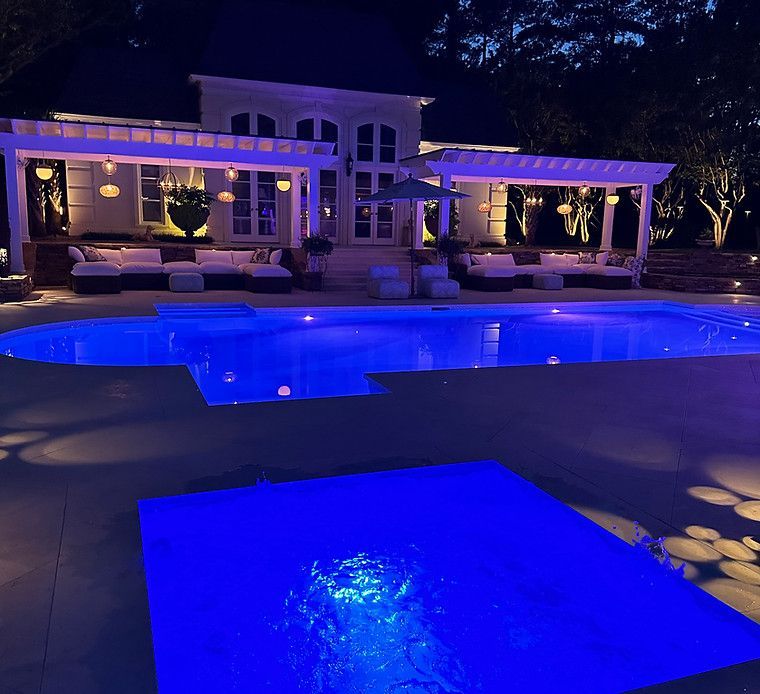 A large swimming pool is lit up at night