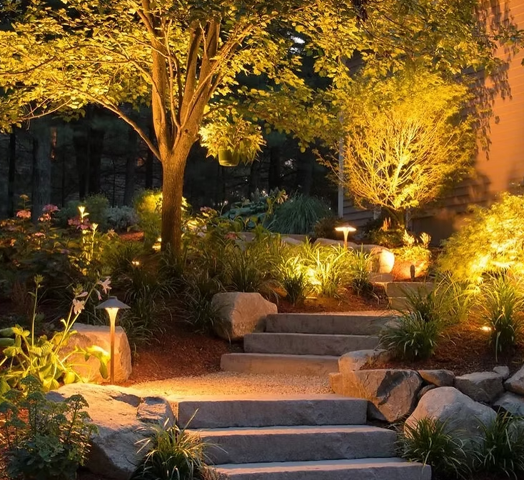 A staircase in a garden is lit up at night