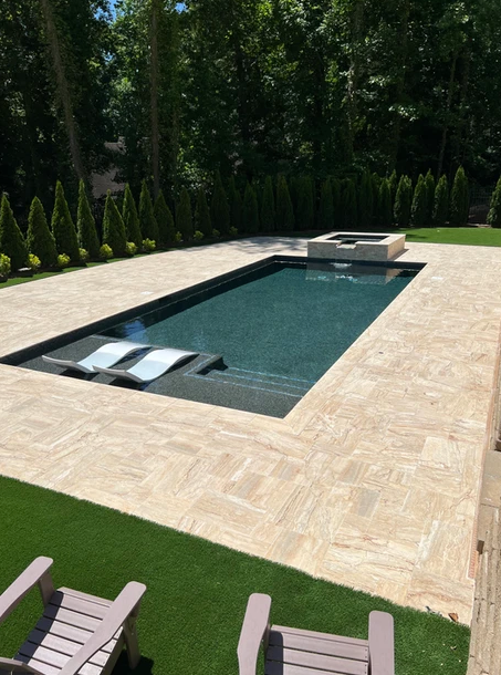 A large swimming pool surrounded by chairs and trees