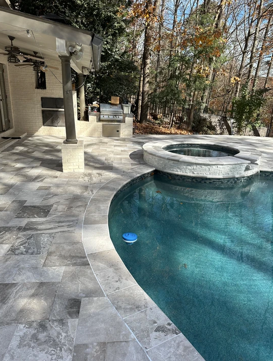 A large swimming pool with a hot tub in the middle of it.
